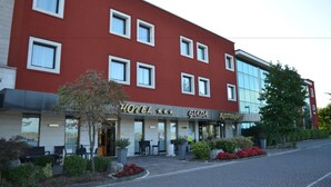 A hotel with a red facade, multiple windows, outdoor seating, and a restaurant sign. - Giada Hotel Ristorante (Grumolo delle Abbadesse)