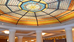 A restaurant with a large, colorful stained glass ceiling and wooden tables and chairs. - Giada Hotel Ristorante (Grumolo delle Abbadesse)