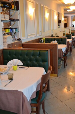 A restaurant with booths and tables, some with white tablecloths. - Giada Hotel Ristorante (Grumolo delle Abbadesse)