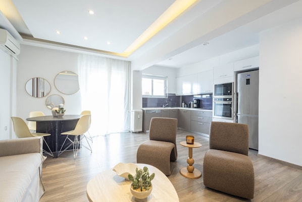 Una sala de estar moderna con comedor, cocina y un ventanal grande.