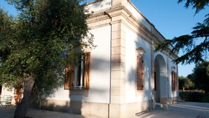 A building with classical architecture, featuring a central arched doorway and columns.
