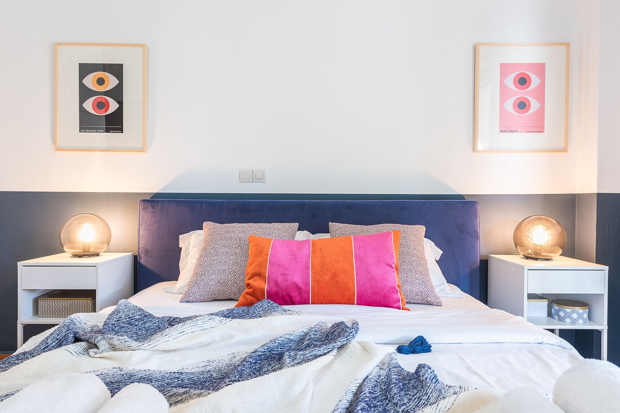A neatly arranged bedroom with a bed, pillows, and bedside tables.
