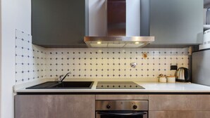 A modern kitchen with a stainless steel range hood, a sink, and a built-in oven. - Apartment Cappelle Medicee Florence by Mmega (Firenze)
