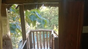 Una escalera de madera que conduce a un balcón con barandilla de metal.