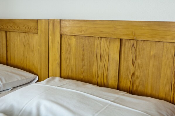 A bed with a wooden headboard and white bedding.
