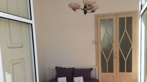A bedroom with a bed, two pillows, a nightstand, and a window. - Apartamento Casino Praia I, center, wi-fi, cable TV (Figueira da Foz)