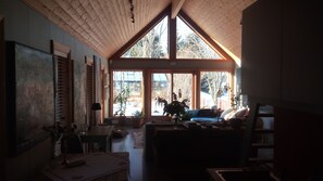 A cozy room with a sloped ceiling, large windows, and a view of the outdoors. - Bø Art Studio (Sortland)