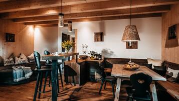 Un interior rústico de madera con una mesa de comedor, sillas y un banco.