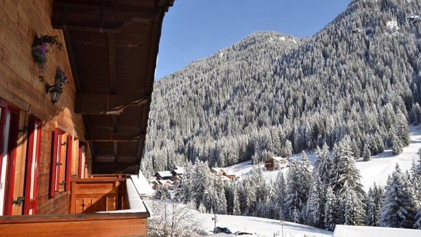 A wooden building with a balcony overlooking a snowy mountain landscape. - Cesa Rotic (Canazei)