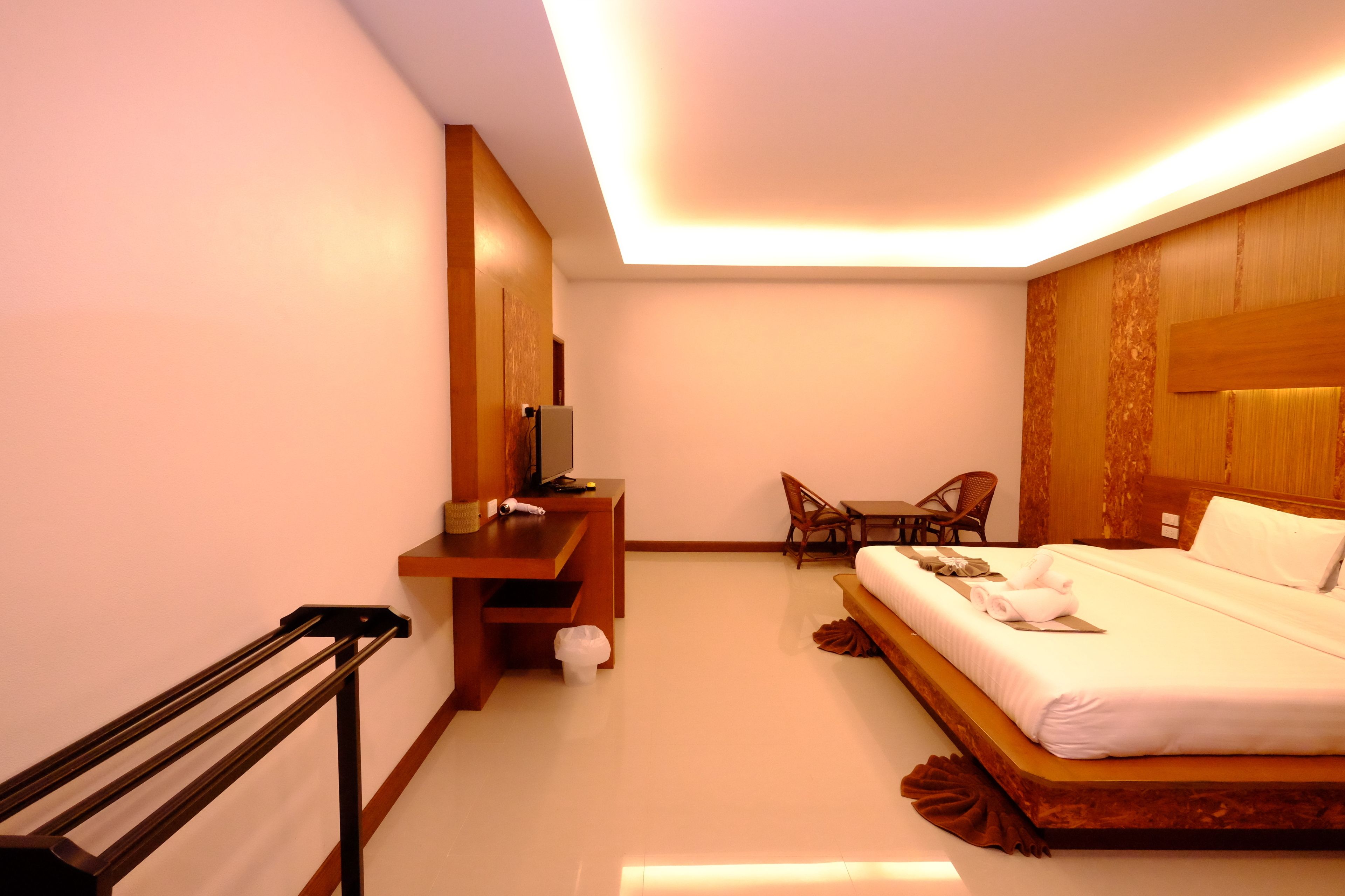 A hotel room with a bed, a desk, a chair, and a TV.