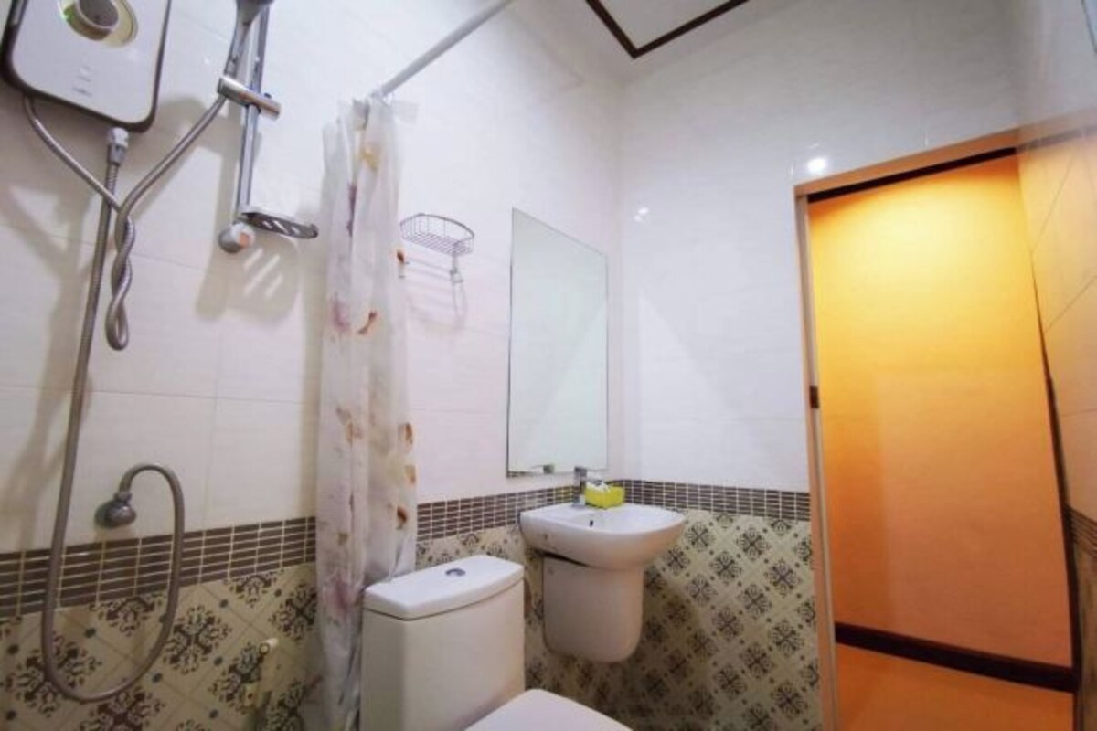 Une salle de bain équipée de toilettes, d’un lavabo et d’une douche.