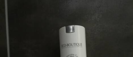 Una botella de champú y gel de ducha ECO-BOUTIQUE.