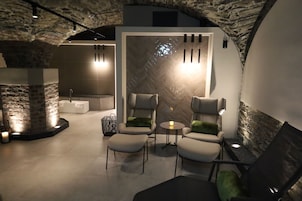 Un área de estar moderna con paredes y chimenea de piedra, y un mobiliario contemporáneo.