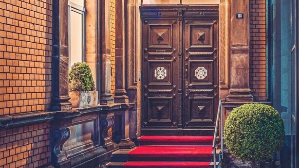 A building entrance with double doors, a red carpet, and a sign reading 'SALVE'. - Hotel Villa Sanct Peter (Bad Neuenahr-Ahrweiler)