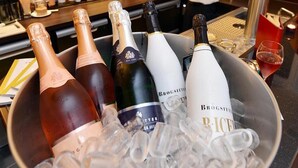 A bar area with a bucket of champagne bottles and ice, a bartender, and a variety of liquor bottles in the background. - Hotel Villa Sanct Peter (Bad Neuenahr-Ahrweiler)