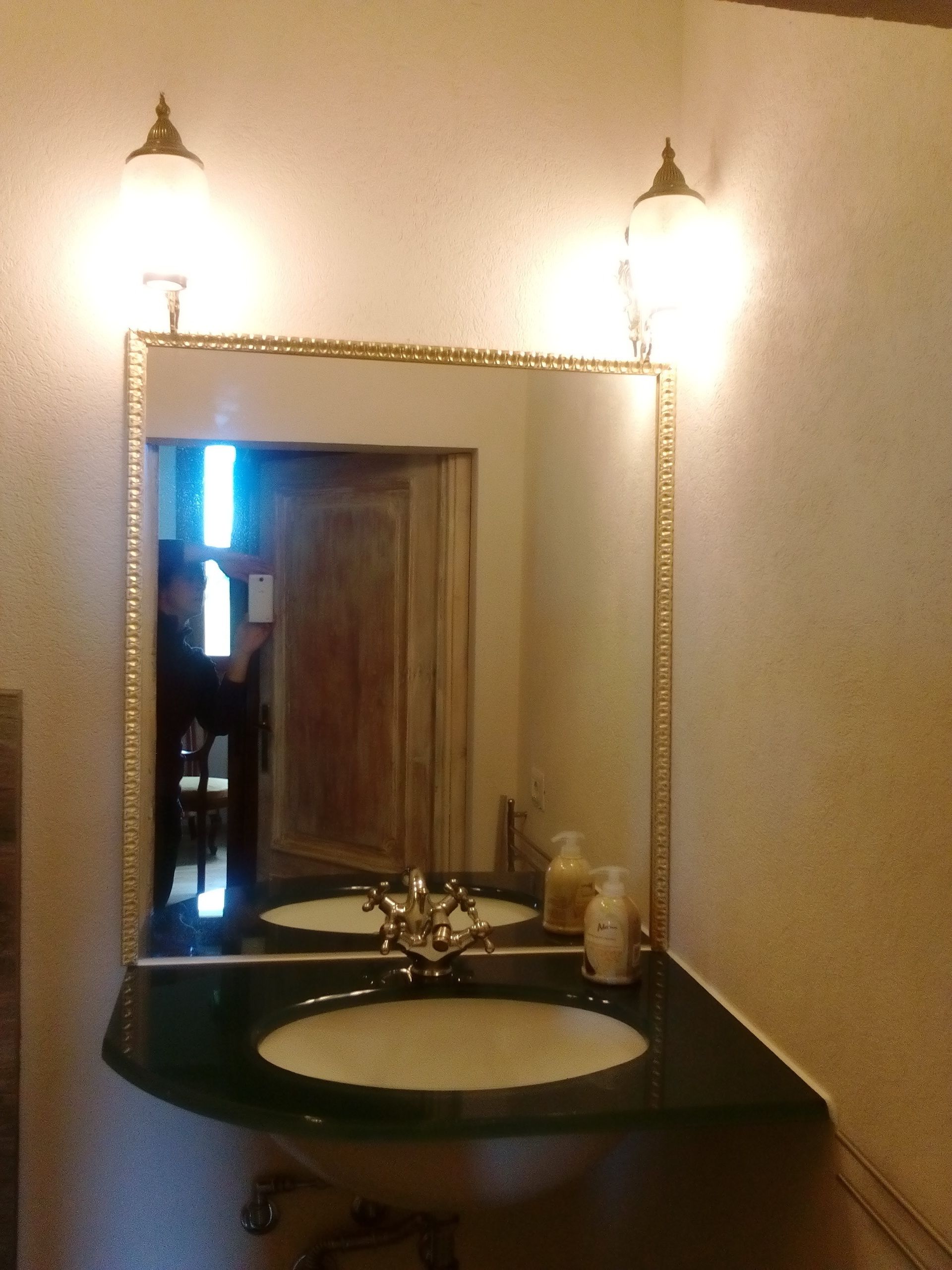 A bathroom with a large mirror, two sinks, and a vanity.