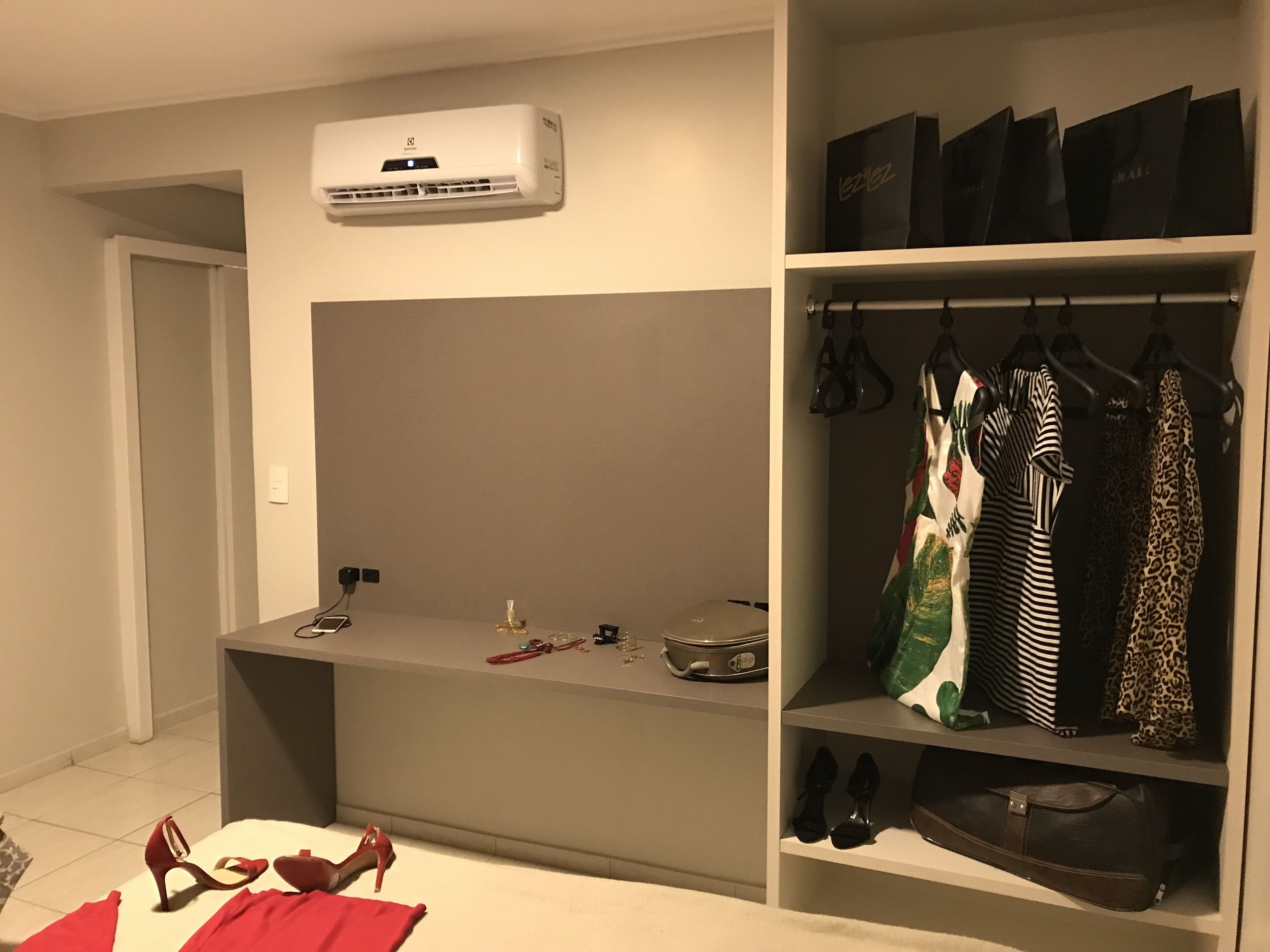 A bedroom with a built-in wardrobe, a bedside table with a lamp, and a suitcase on the floor.