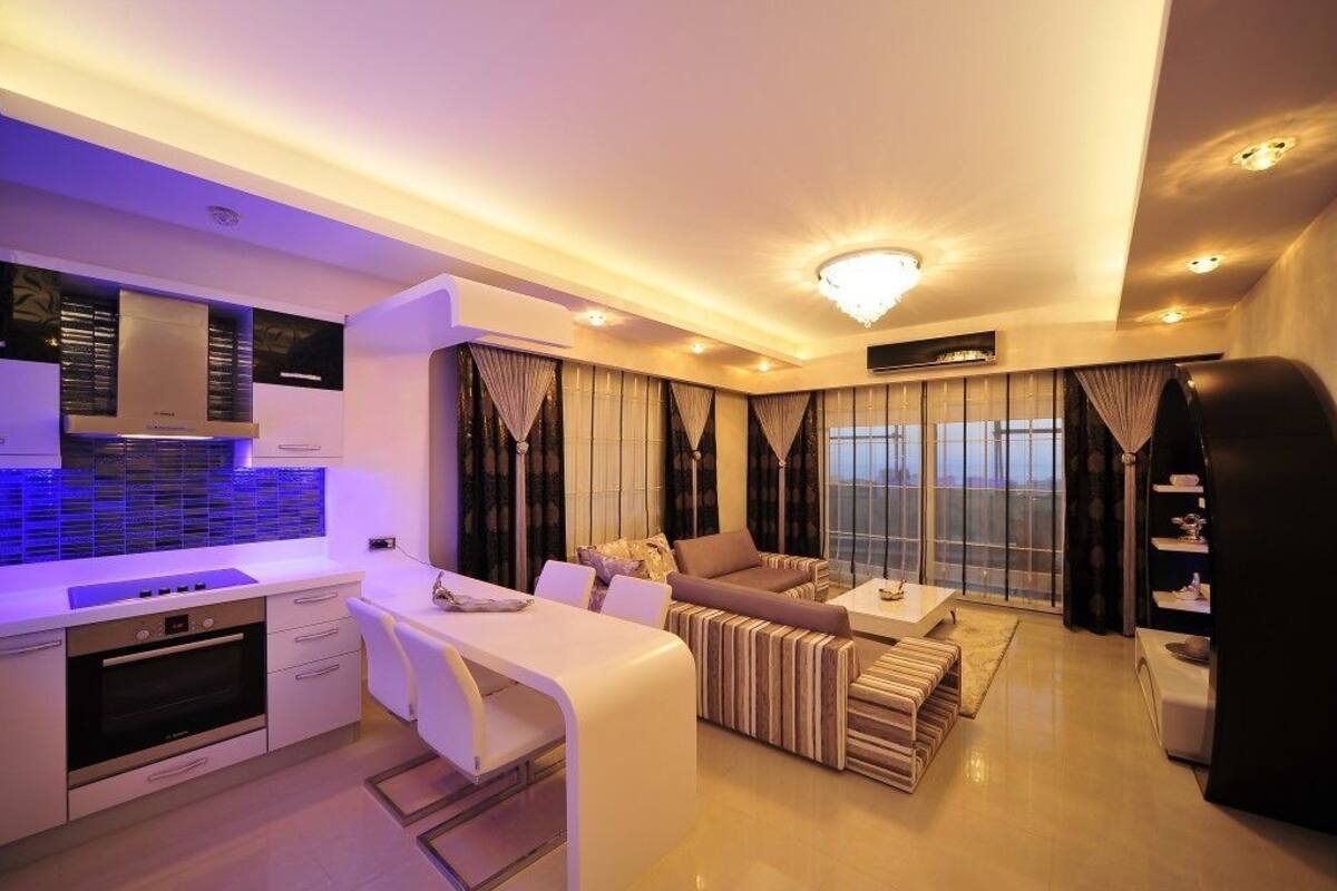 Una sala moderna con un sofá, un comedor y una cocina.