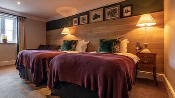 A double bed with two pillows, a nightstand with a lamp, and a window with curtains.