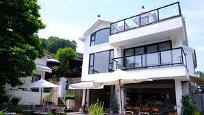 A modern two-story building with outdoor seating and a cafe. - Hangzhou Sansu Hotel (Hangzhou)