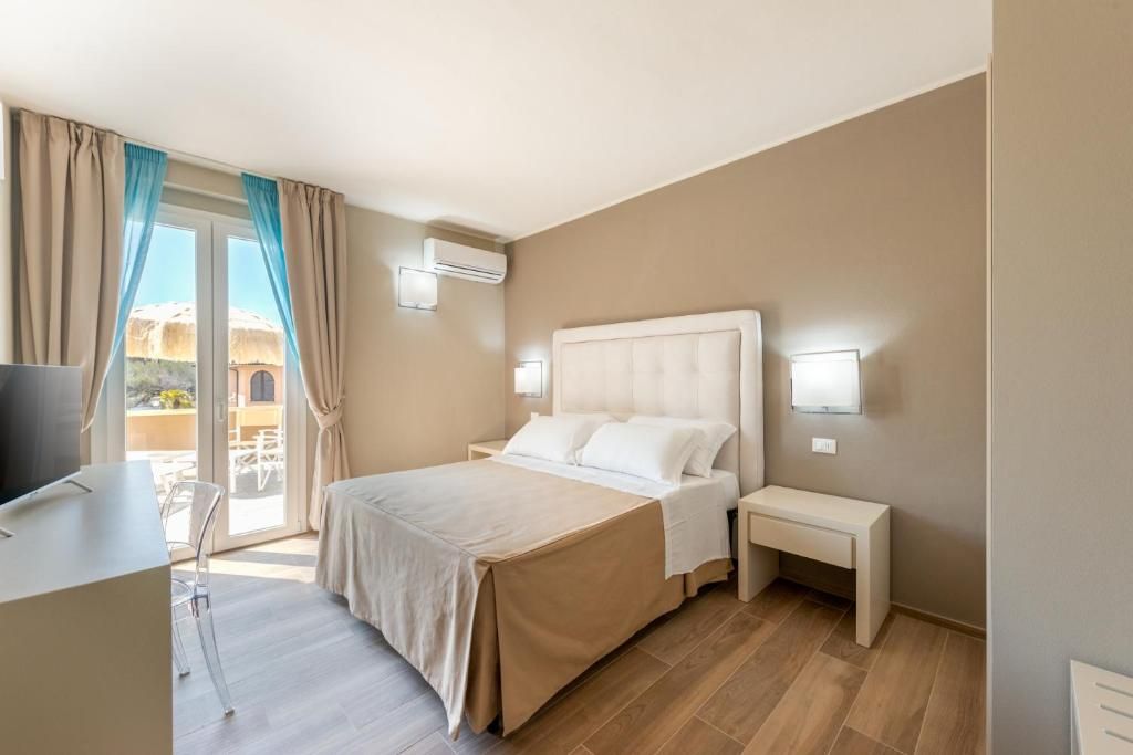 Una camera d'albergo con un letto, comodini, una scrivania e una sedia.