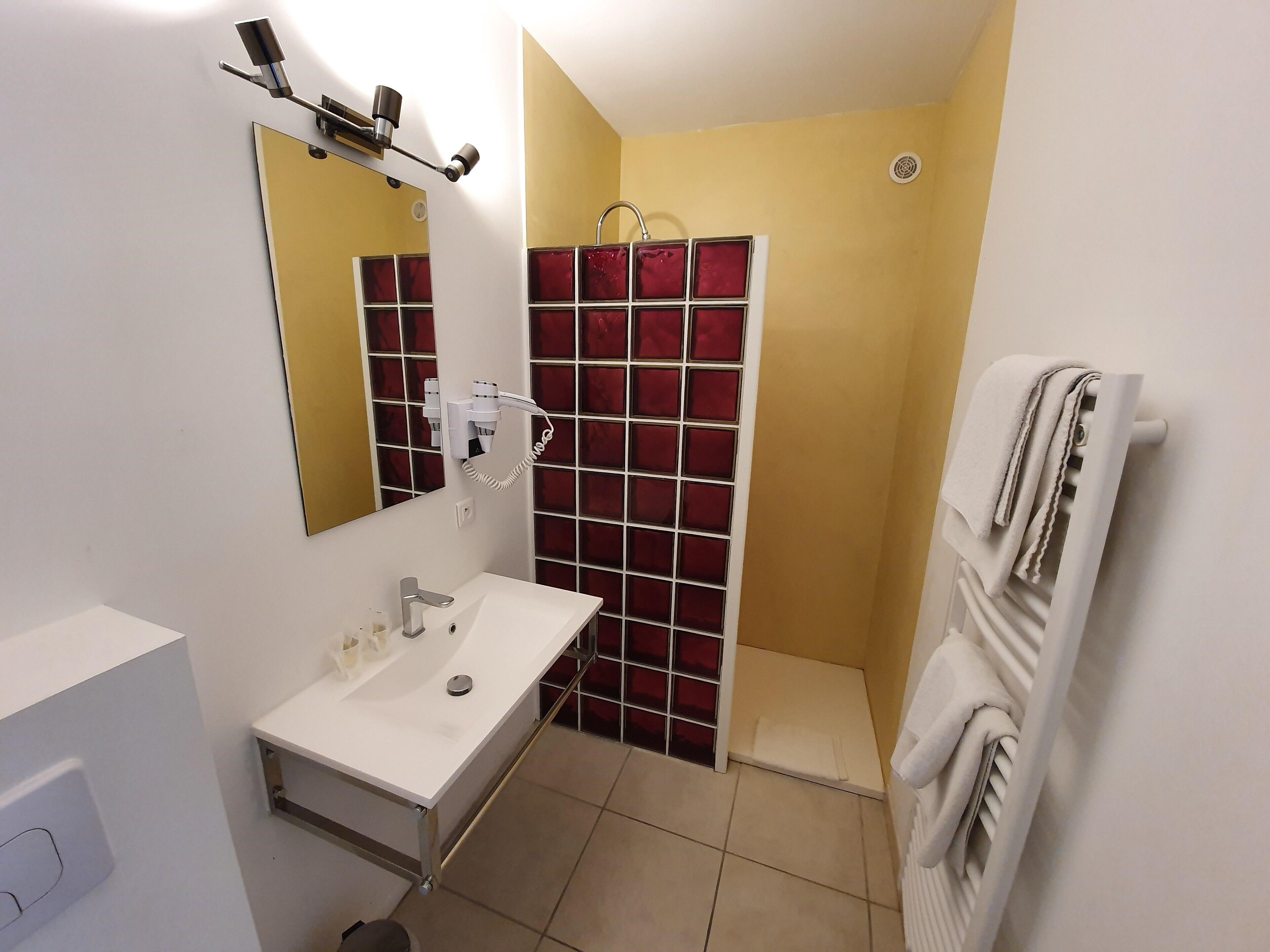 A bathroom with a white sink, mirror, and towel rack.