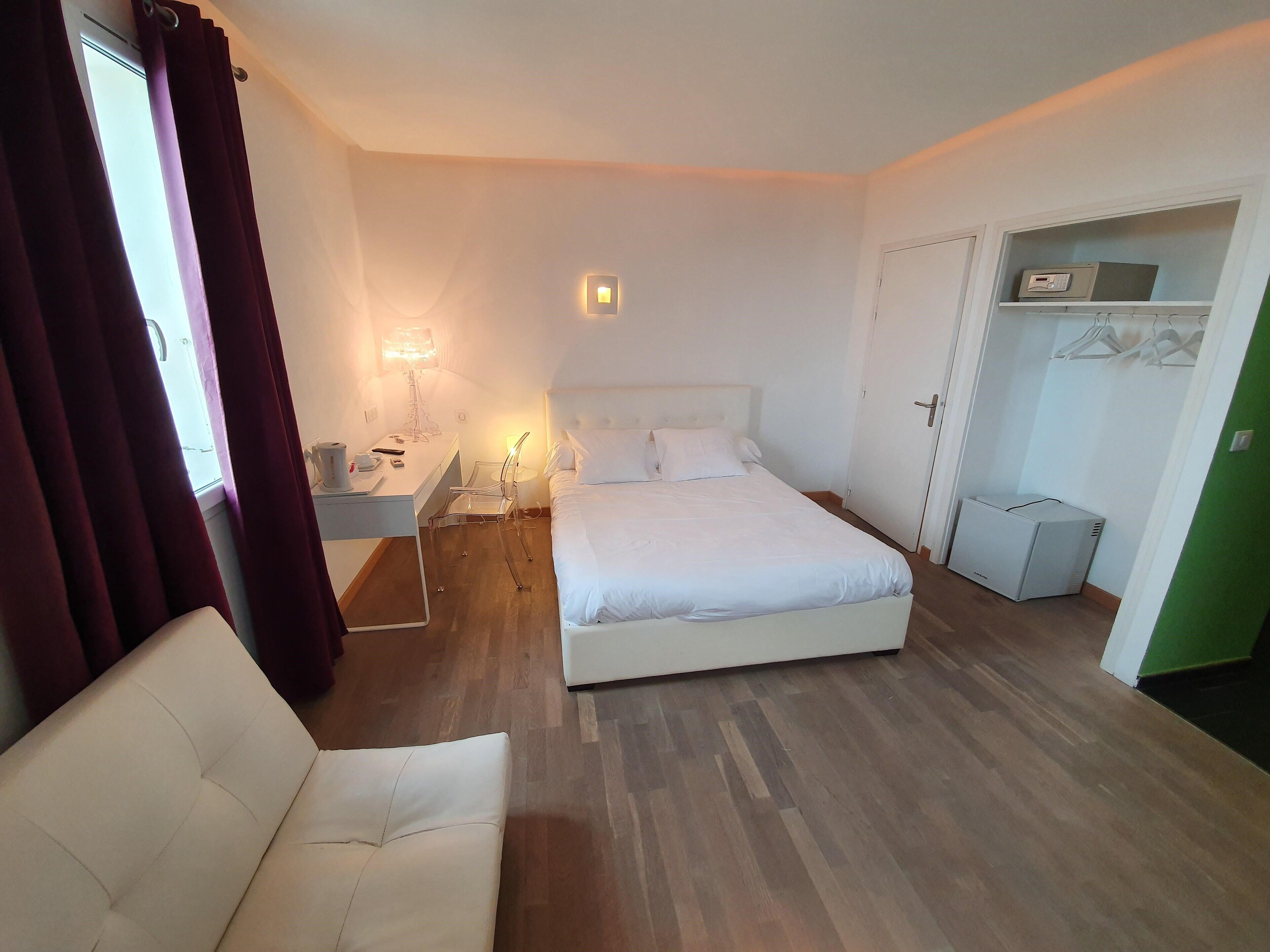 A bedroom with a bed, bedside table, lamp, and a wardrobe.