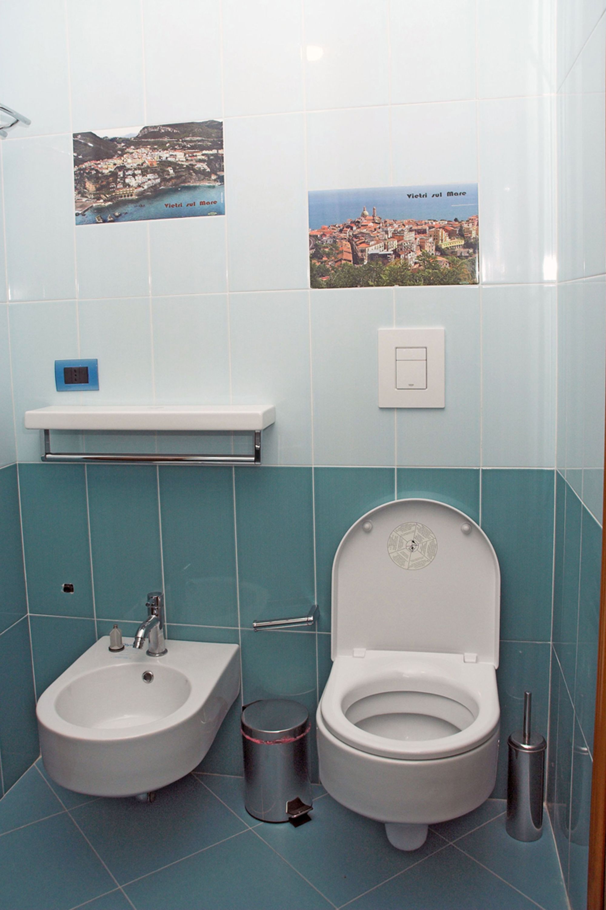 A bathroom with a bidet, sink, and toilet.