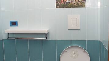 A bathroom with a bidet, sink, and toilet.