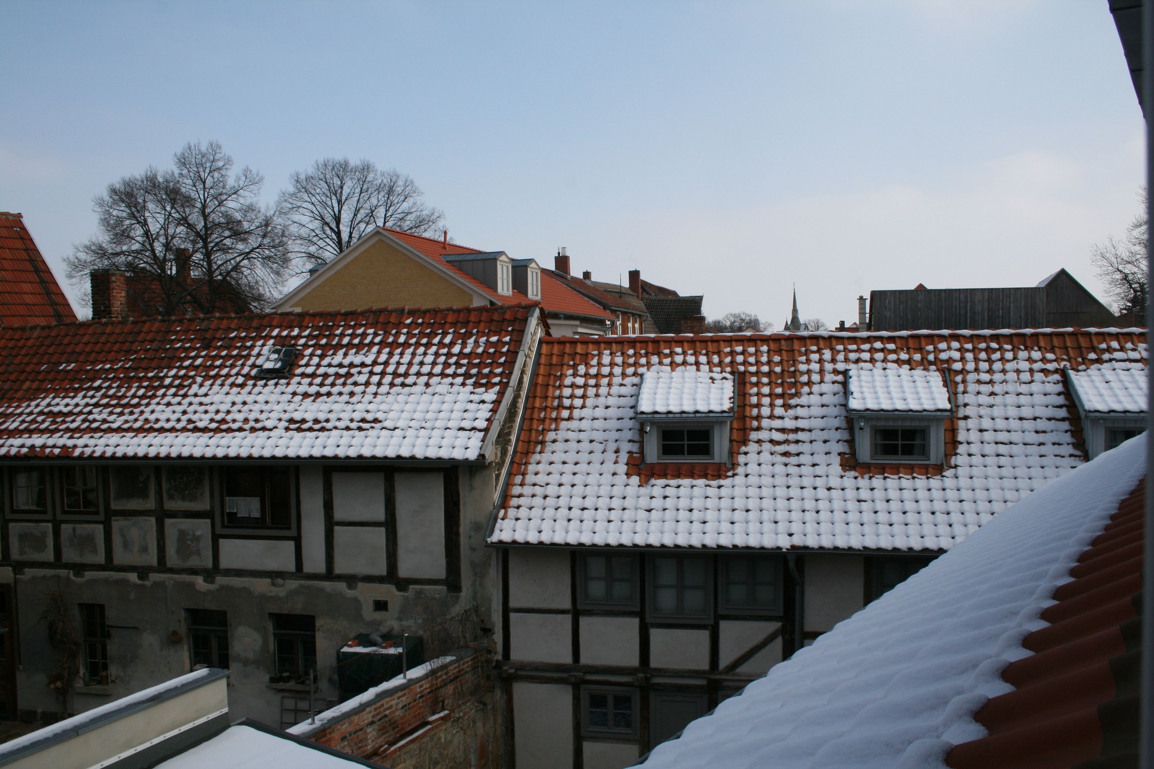 A traditional half-timbered building with snow-covered roofs and a visible chimney.