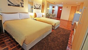 A hotel room with two beds, a desk, and a dining area. - BSA Mansion (Makati)