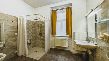 Un baño con ducha, inodoro y lavamanos.