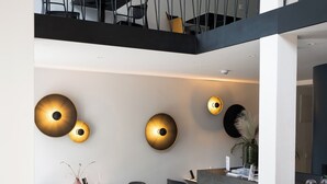 A modern dining area with a marble table, black chairs, and a central island with a gold tray. - Doma Zagreb (Zagreb)