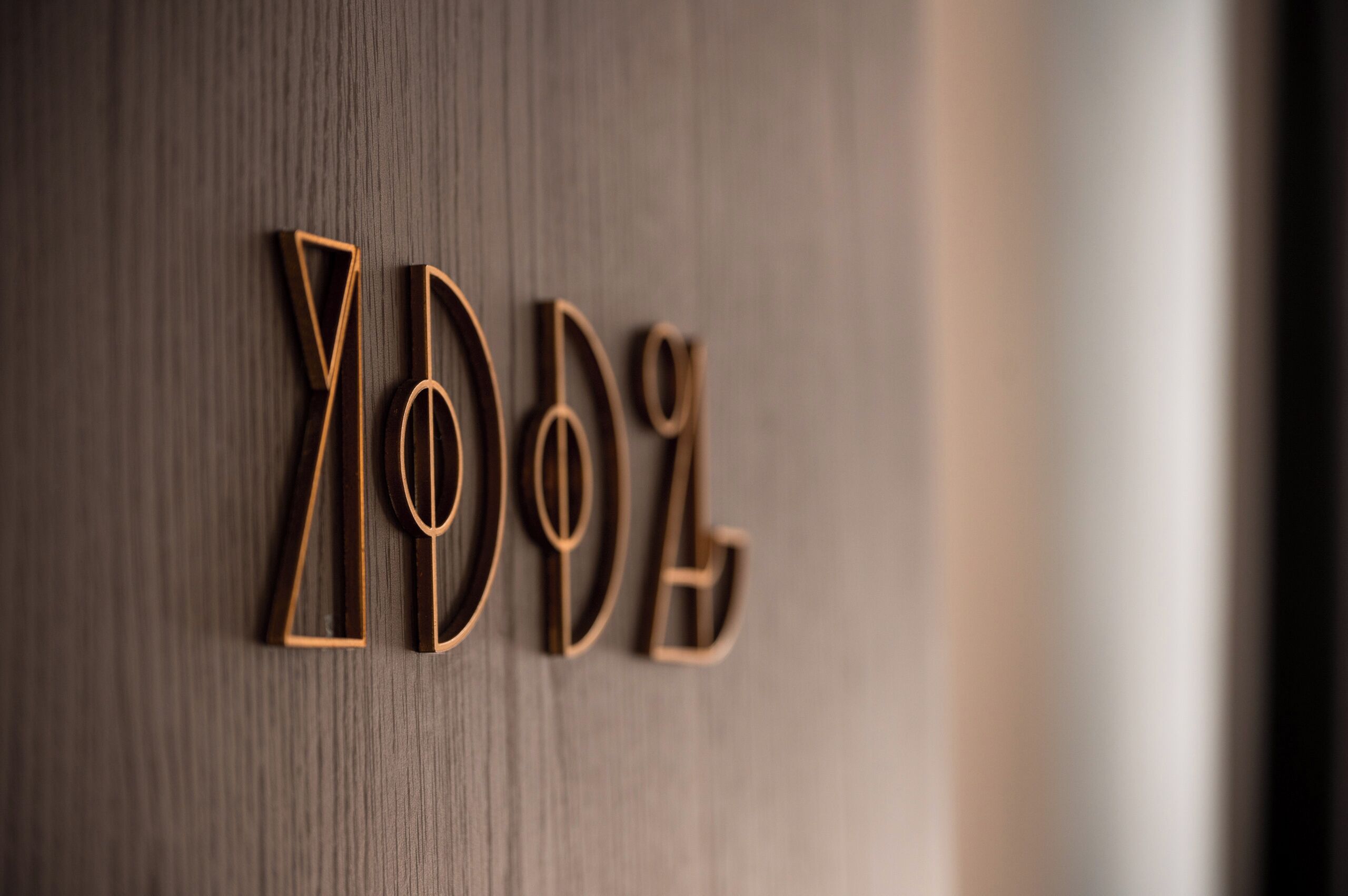 Houten letters die 'YOLO' spellen, bevestigd aan een muur.