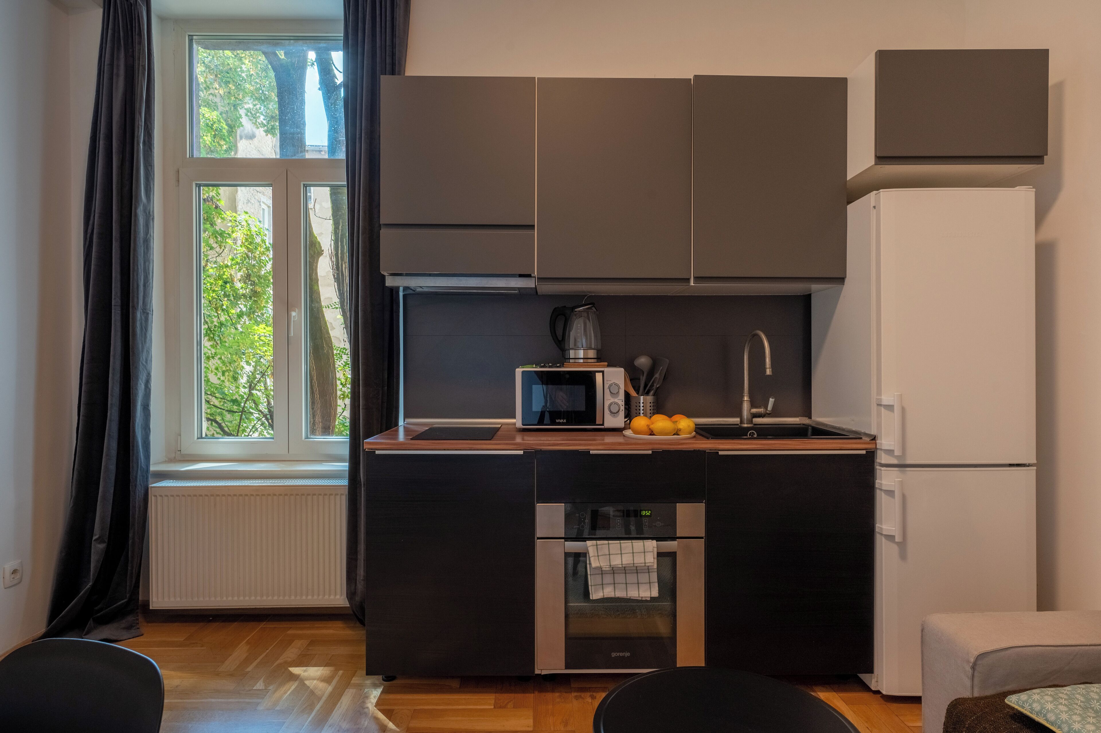 Eine kleine Küche mit Einbauofen, Mikrowelle und Kühlschrank.
