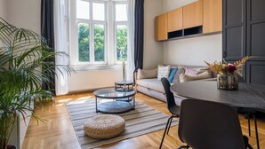 A modern living room with a sofa, a dining table, a coffee table, and a potted plant. - Doma Zagreb (Zagreb)