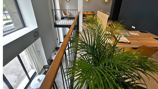 A modern office space with a long table, multiple chairs, and a balcony with a railing. - Doma Zagreb (Zagreb)