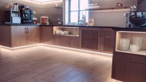 Una cocina moderna con armarios de madera, una cafetera y cristalería sobre la encimera.