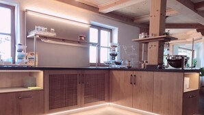 Una cocina moderna con armarios de madera, una encimera negra y un ventanal que proporciona luz natural.