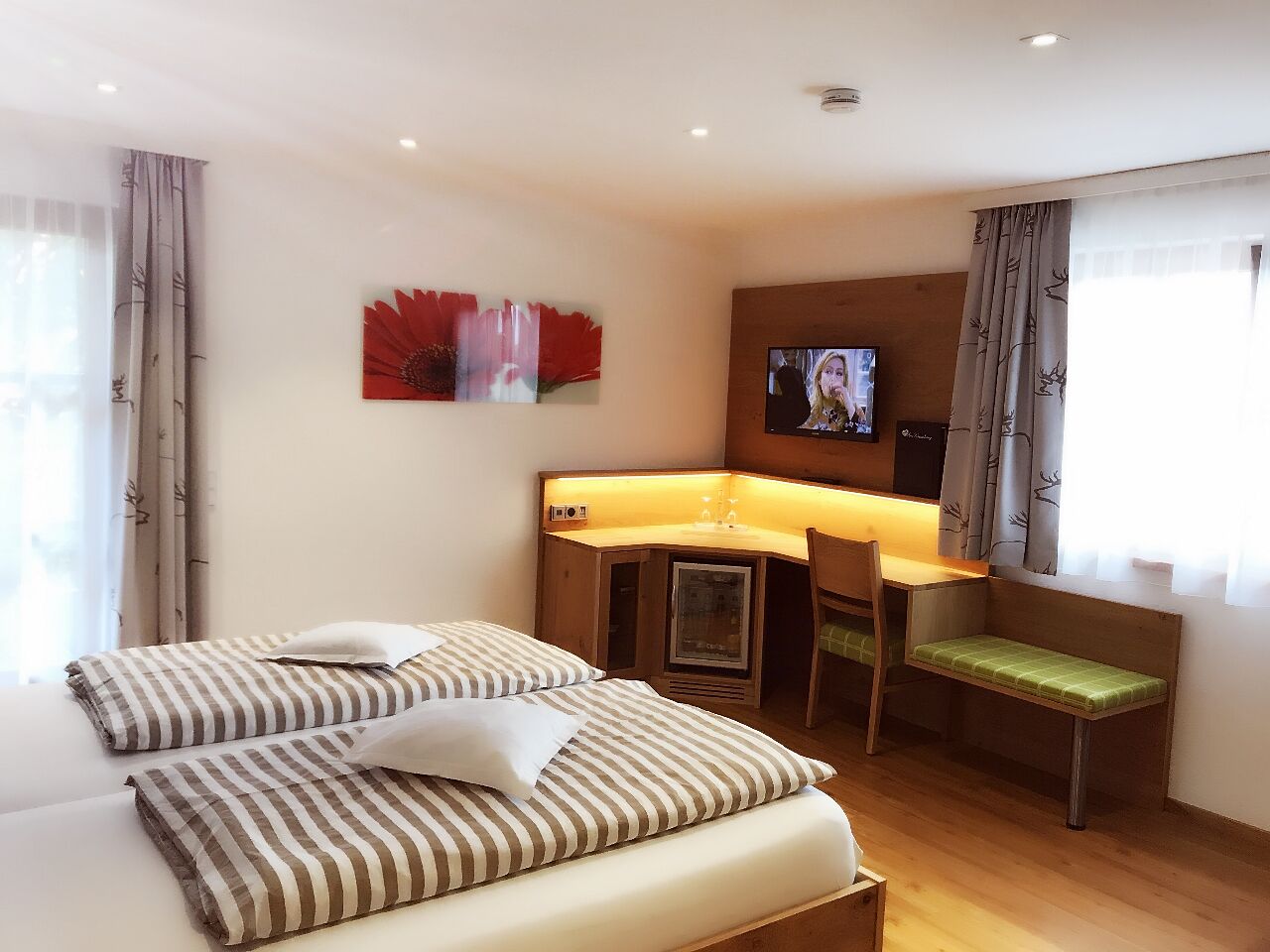 Una habitación de hotel con cama, escritorio, silla y televisión.