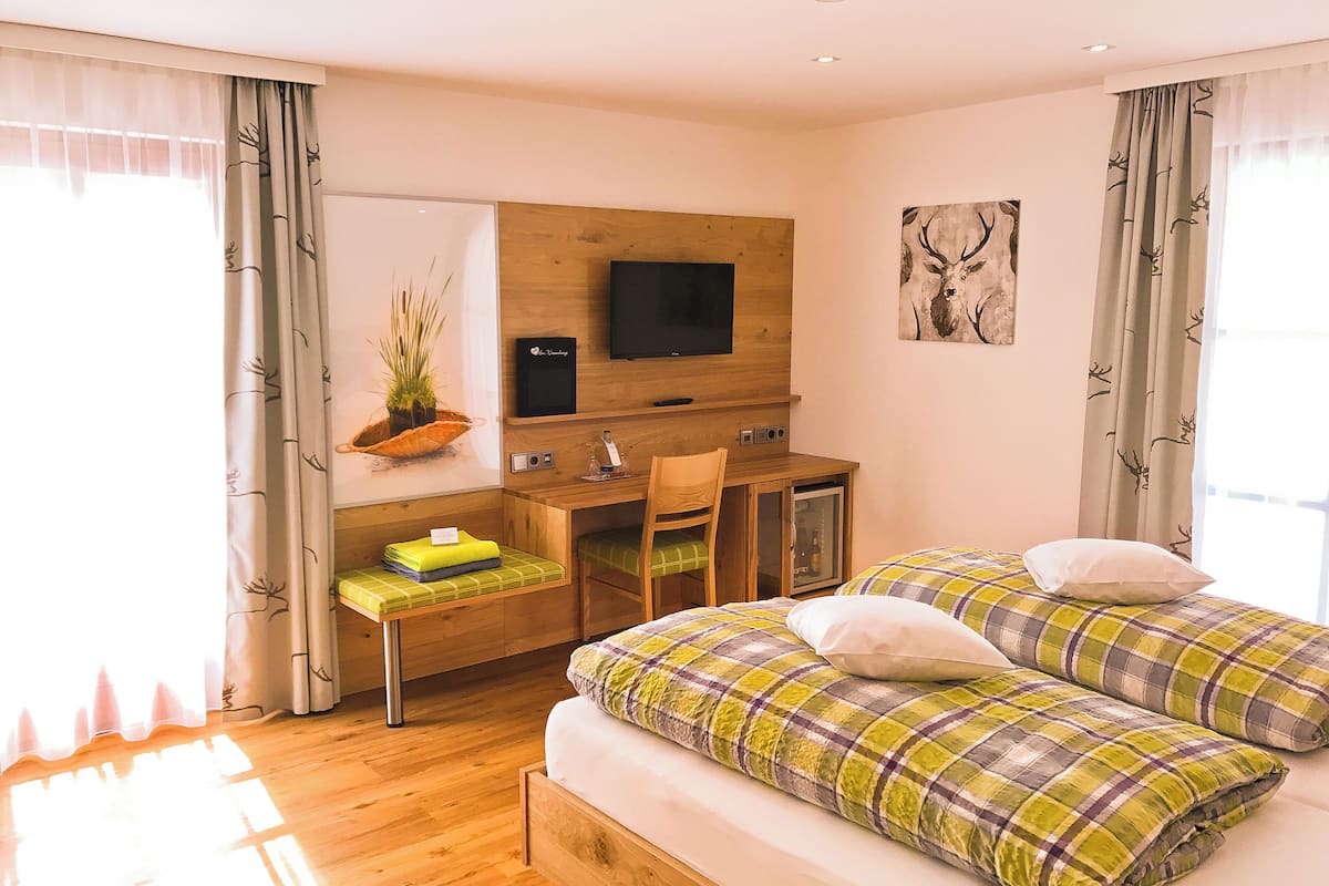 Un dormitorio con cama, escritorio y televisor.