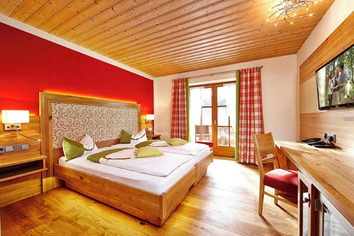 Un dormitorio con una cama de madera, un escritorio y un televisor.