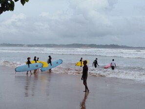 Eine Strandansicht mit Menschen, die Surfbretter tragen.