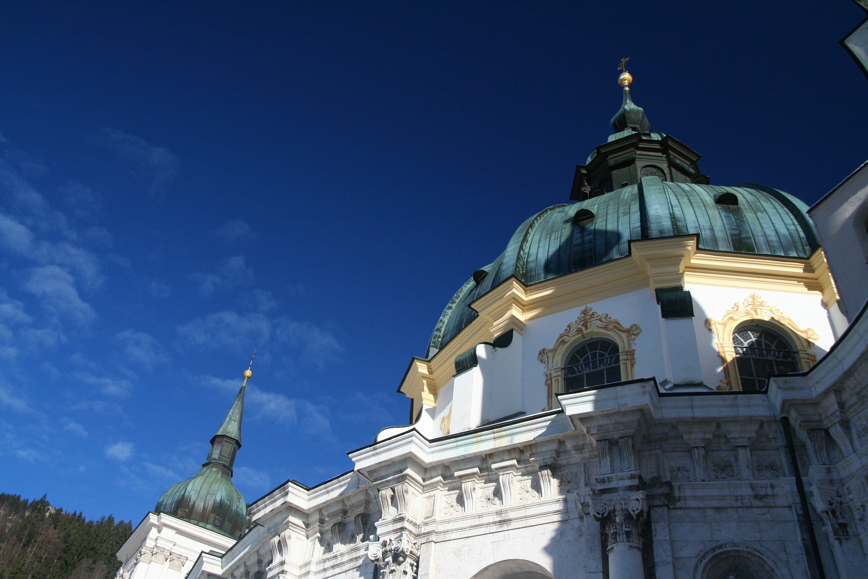 Ein historisches Gebäude mit einer markanten Kuppel und einem kleineren Turm, umgeben von blauem Himmel.