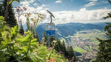 Un teleférico con el número 4, rodeado de vegetación y montañas al fondo.