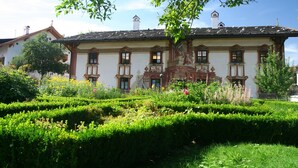 A historic building with a symmetrical facade, multiple windows, and a central balcony. - Mammhofer Suite & Breakfast (Oberammergau)