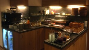 A kitchen with a refrigerator, coffee machine, and various food items on display. - Mammhofer Suite & Breakfast (Oberammergau)