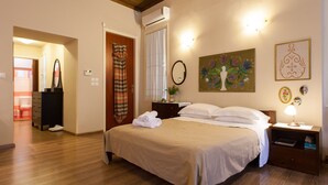 A bedroom with a bed, nightstand, and a painting on the wall.