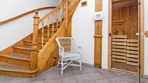 A wooden staircase with a white wicker chair in front.