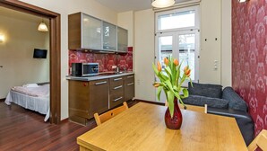 A compact living space with a kitchenette, a dining area, and a seating area with a sofa.